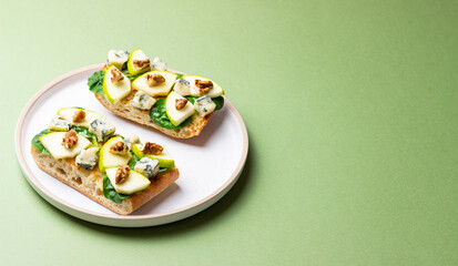 Bruschetta with spinach, honey, blue cheese, pear, and nuts. Healthy eating. Vegetarian food.