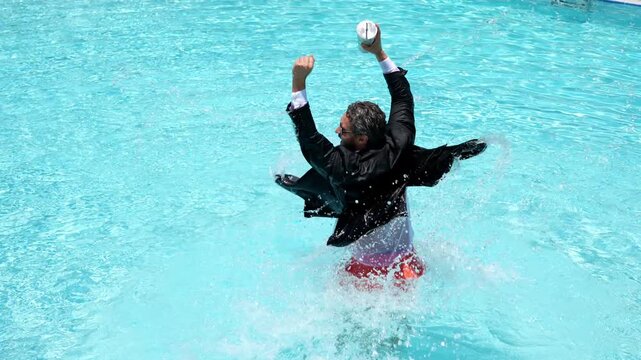 Excited business man in suit jump in swim pool water. Summer vacation, business on sea beach. Summer rest, business people concept. Wealthy business man relaxing in swimming pool.