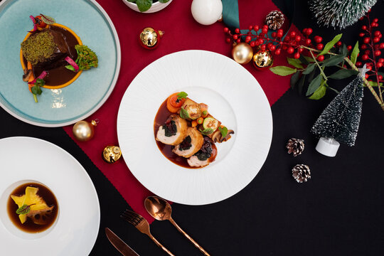 A collection of artfully plated dishes, featuring an array of delectable food.  The arrangement includes plates and festive elements, evoking a celebratory mood 