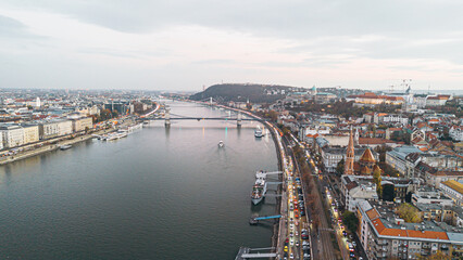 Obraz premium Aerial view of Budapest cityscape at dusk with illuminated bridges and buildings along the Danube River.