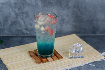 Refreshing fruit punch with vibrant blue hues, sparkling soda, and mixed fruit cubes. Served chilled, this drink blends tropical flair and fruity sweetness for any occasion.