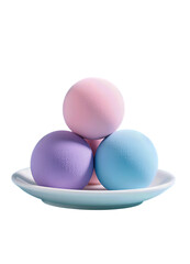 Three colorful spheres stacked on a white dish