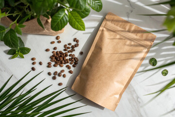 Blank brown paper pouch mockup with coffee beans and green leaves around