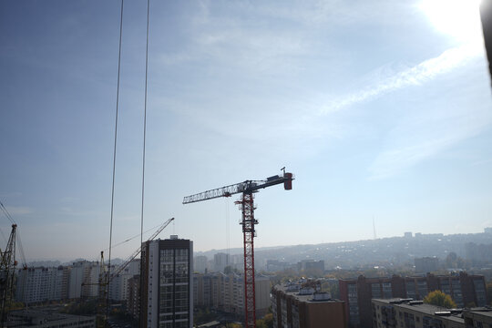 Lots of construction cranes with the city in the background