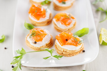 plate of canapes with cheese cream and smoked salmon