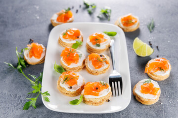 Canapes with fresh cheese and smoked salmon for holiday or event, top view
