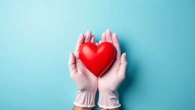 Hands In Gloves Holding Red Heart