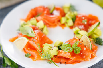 Holiday dining salad plate. Close up on smoked salmon salad with herbs and avocado