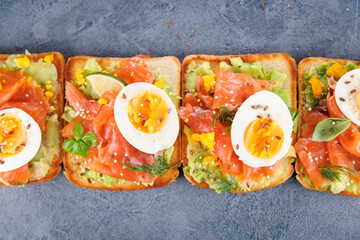 bread toast with avocado, smoked salmon and egg. breakfast or brunch protein toast