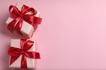 Top view of Christmas gifts with decorations on pink background
