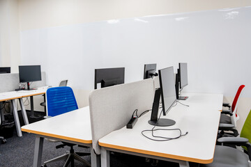 A office coworking space featuring PC monitors on tables