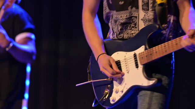 Guitarist playing electric guitar solo on a concert stage