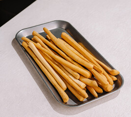 Baked breadsticks served on a metal tray ready for enjoyment at a meal