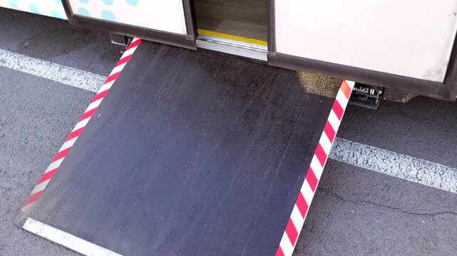 Bus deploying wheelchair accessibility ramp for disabled passengers