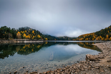 Mountain Lake with Autumn Forest Reflections, Misty Mountains and Clear Water