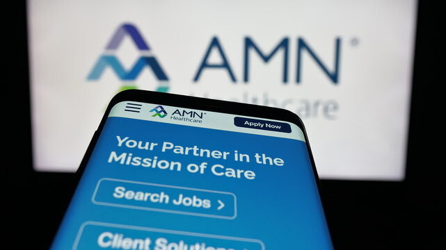 Stuttgart, Germany - 11-08-2025: Mobile phone with website of staffing company AMN Healthcare Services Inc. on screen in front of logo. Focus on top-left of phone display.