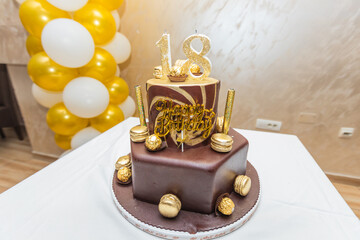 Luxury 18th birthday cake with glittering gold candles and chocolate decoration