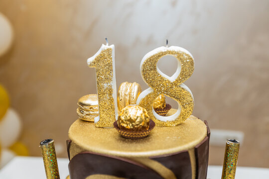 Luxury 18th birthday cake with glittering gold candles and chocolate decoration