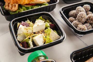 Light fresh salad made with feta cubes beet pieces greens and seeds served in container