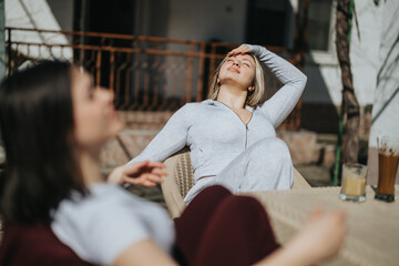 Two women enjoying a sunny afternoon outdoors, unwinding on a relaxing day together.