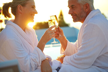 Love, sunset or couple poolside with toast, bonding or anniversary celebration on holiday trip....