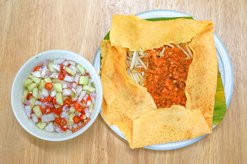 The Vietnamese savory crepe common fillings include a mix of thinly sliced pork belly, shrimp, mung beans, and bean sprouts.