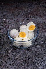 Peeled hard-boiled eggs in glass bowl on granite countertop
