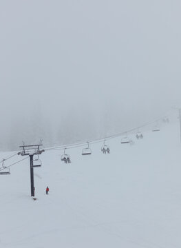 Skiers riding chairlift on foggy bogus basin mountain