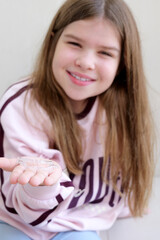 Teen girl showing transparent aligners in hands, comfortable teeth straightening options for children. Clean natural image ideal for orthodontic ads, dental care guides and family health content