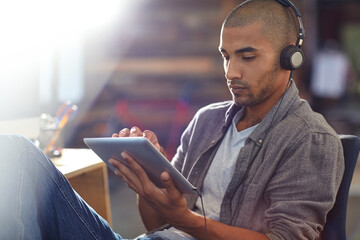 Gaming, headphones and tablet with developer man in office for software update or testing. App, playing and streaming with game designer in creative workplace for graphics or video calibration