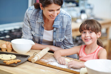 Smile, cookies and baking with mother and daughter in kitchen for learning, recipe and food. Teaching, dessert and cooking with woman and child in family home for biscuit, growth and baker skill