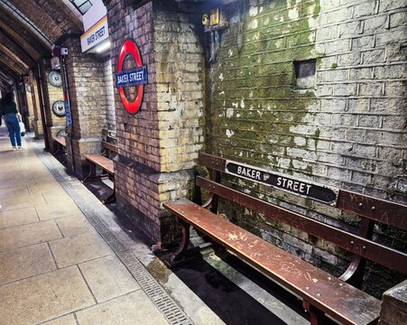 LONDON, UK-JULY 14 2025 :An iconic Baker Street Underground Station wooden bench and roundel. Baker Street Underground Station is famous for being the world's oldest underground station opened in 1863