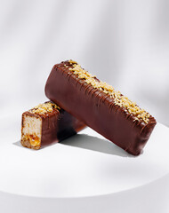 Delicious chocolate-coated snack bars displayed on a white pedestal