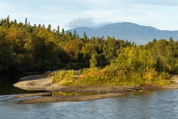 River water flowing with forest hills in early autumn morning light in Sweden