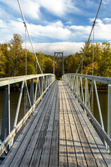Crossing river suspension bridge hiking backpacking Sweden sunrise morning sunlight