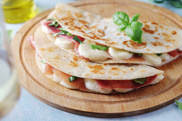 Traditional Italian dish Piadina romagnola - flat bread with mozarella and proscuitto	