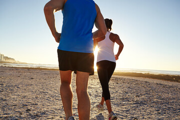 Fitness, running and back of couple on beach for health, workout or training together in morning. Ocean, athletes and man with woman for cardio exercise for sports, wellness or active in summer.