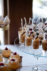 Assorted wedding desserts in elegant glasses on candy bar table
