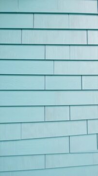 Close-up of a light blue wooden shingle siding with horizontal planks creates a patterned background, perfect for adding text overlay.