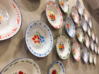 Quirky vintage enamel bowls adorning a wall, a delightful touch of nostalgia and charm for kitchen decor or restaurant design elements.