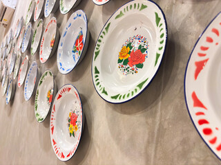 Charming vintage enamel plates adorned with floral designs for a rustic kitchen or dining decor, a nostalgic display of timeless beauty