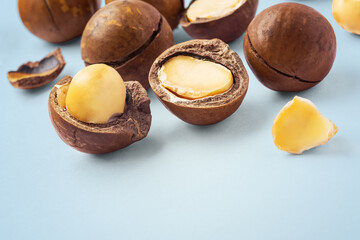 Macadamia nuts with cracked nut and shell  on blue background