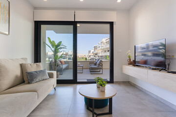Contemporary living room with balcony access and cozy neutral sofa