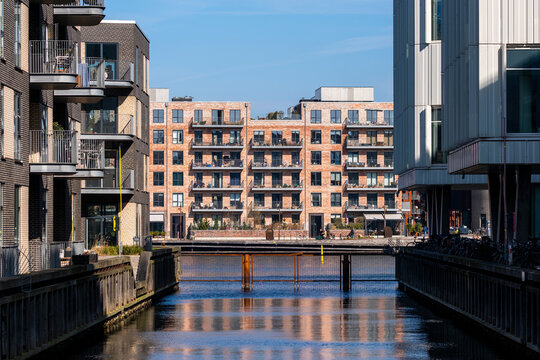 Modern architecture along the waterfront and canal, featuring housing blocks with clean facade, calm reflection, and strong urban identity in copenhagen denmark