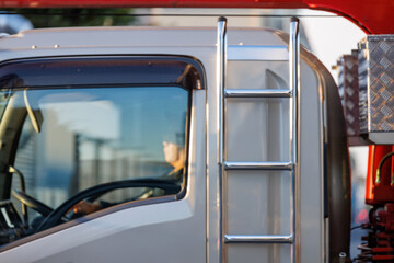 朝日を受けるトラックとドライバー