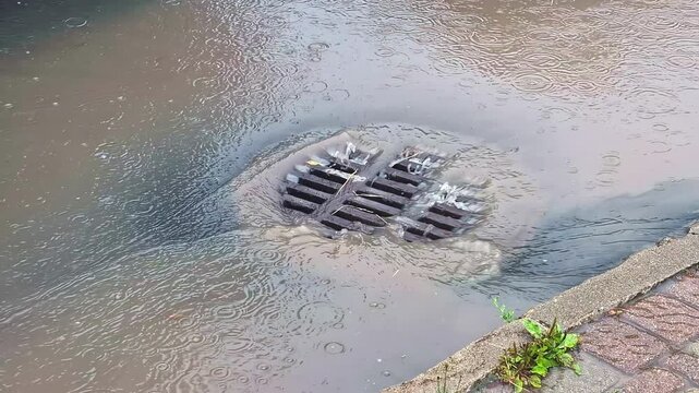 Water flows into a drain during heavy rain in Jelgava, Latvia