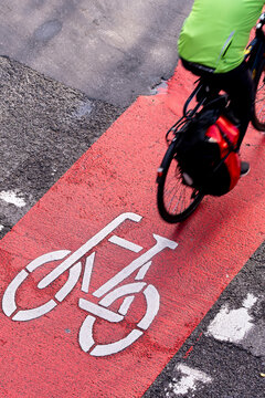 Urban bicycle mobility on red lane with transport motion, asphalt detail and strong graphic elements contributing to a dynamic modern movement scene