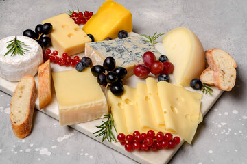 Gourmet cheese platter with craft cheese assortment on a marble platter. hard cheeses, mold cheese, gorgonzola, pecorino, Emmental, Roquefort ,  cheddar