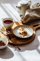 Eine Teetasse und Kekse auf einem Telller im Morgenlicht. Frühstück, Heißgetränk. 