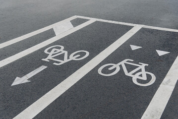white road markings on sidewalk marking beginning and end of bike path